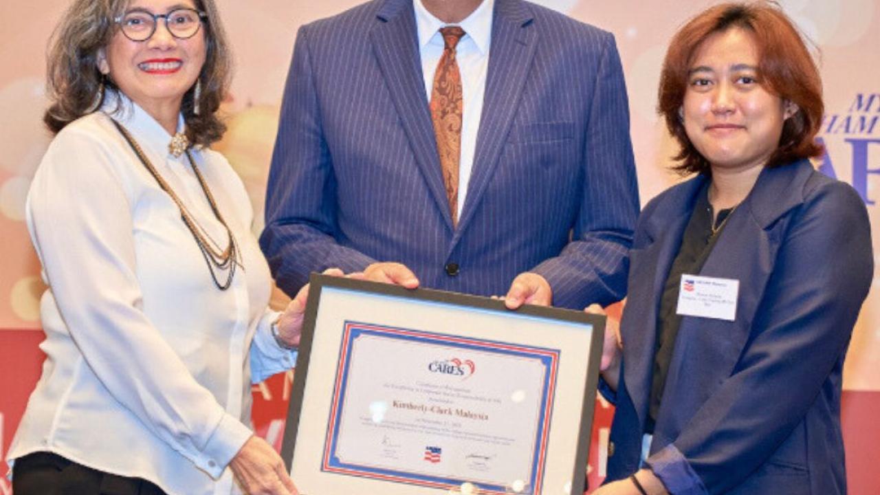 3 People holding a framed certificate 
