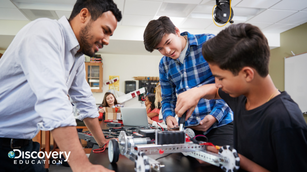 Student working with teacher on building a machine
