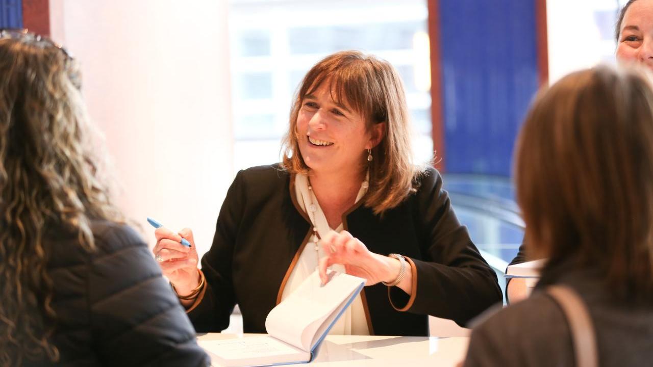 WHC President Margaret O'Gorman signing copies of Strategic Corporate Conservation Planning