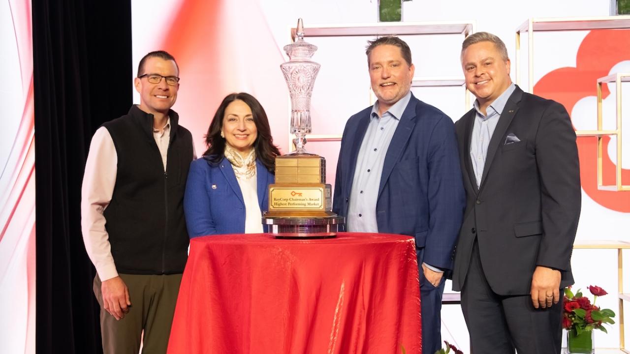 leaders standing around the trophy