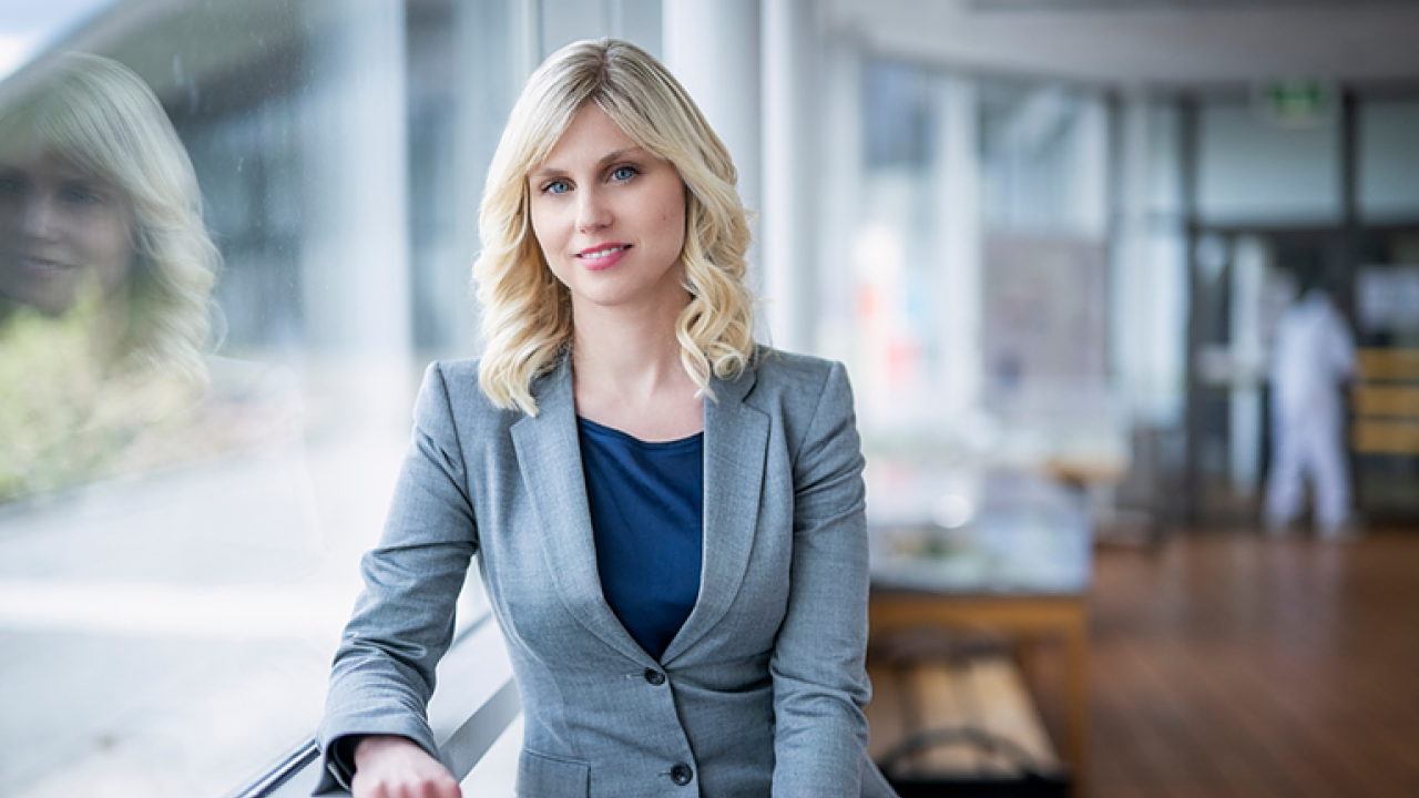 Martina Flemstrom leaning against a window sill in an office setting.
