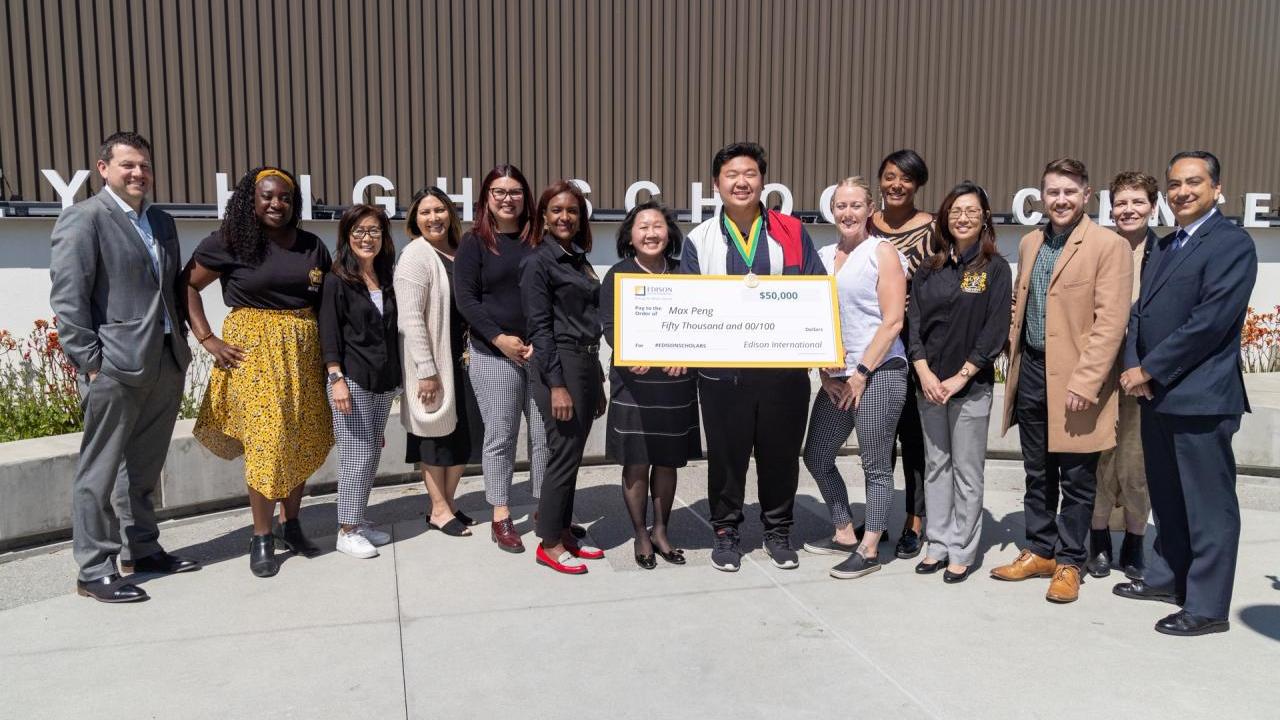 Max Peng with a group of others, holding a large check.