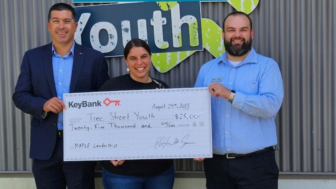 Maine Tree Street Youth team leaders with KeyBank market rep shown holding a grant check.