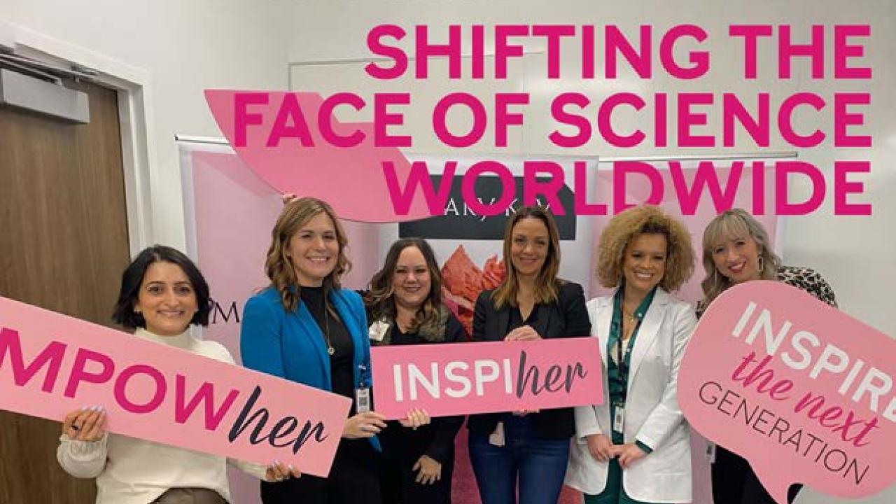 group photo of women holding signs. Reads: "Shifting the face of science worldwide"