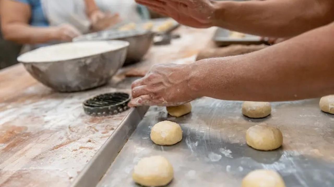 People rolling out dough balls.
