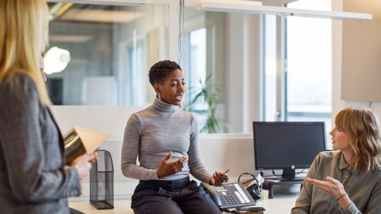 Three women speaking together in an office
