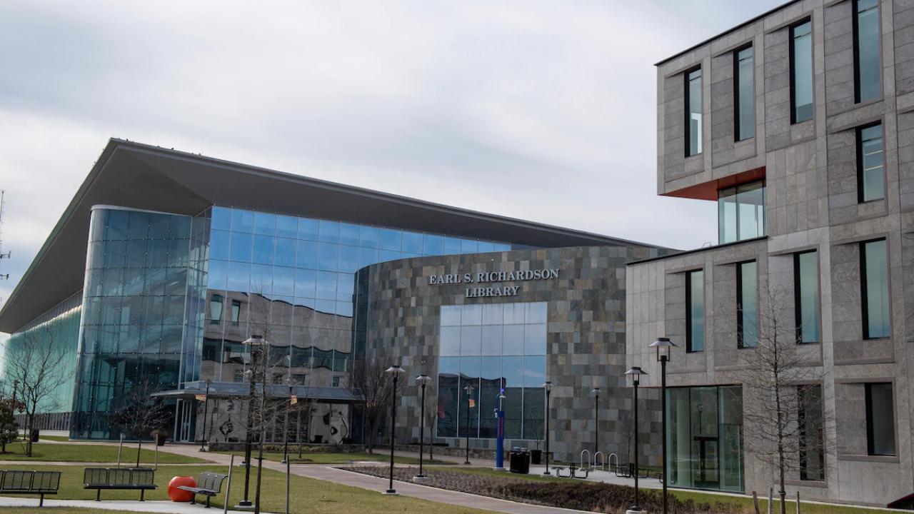 Exterior of the Earl S. Richardson Library. Grassy area with park benches in front of it.