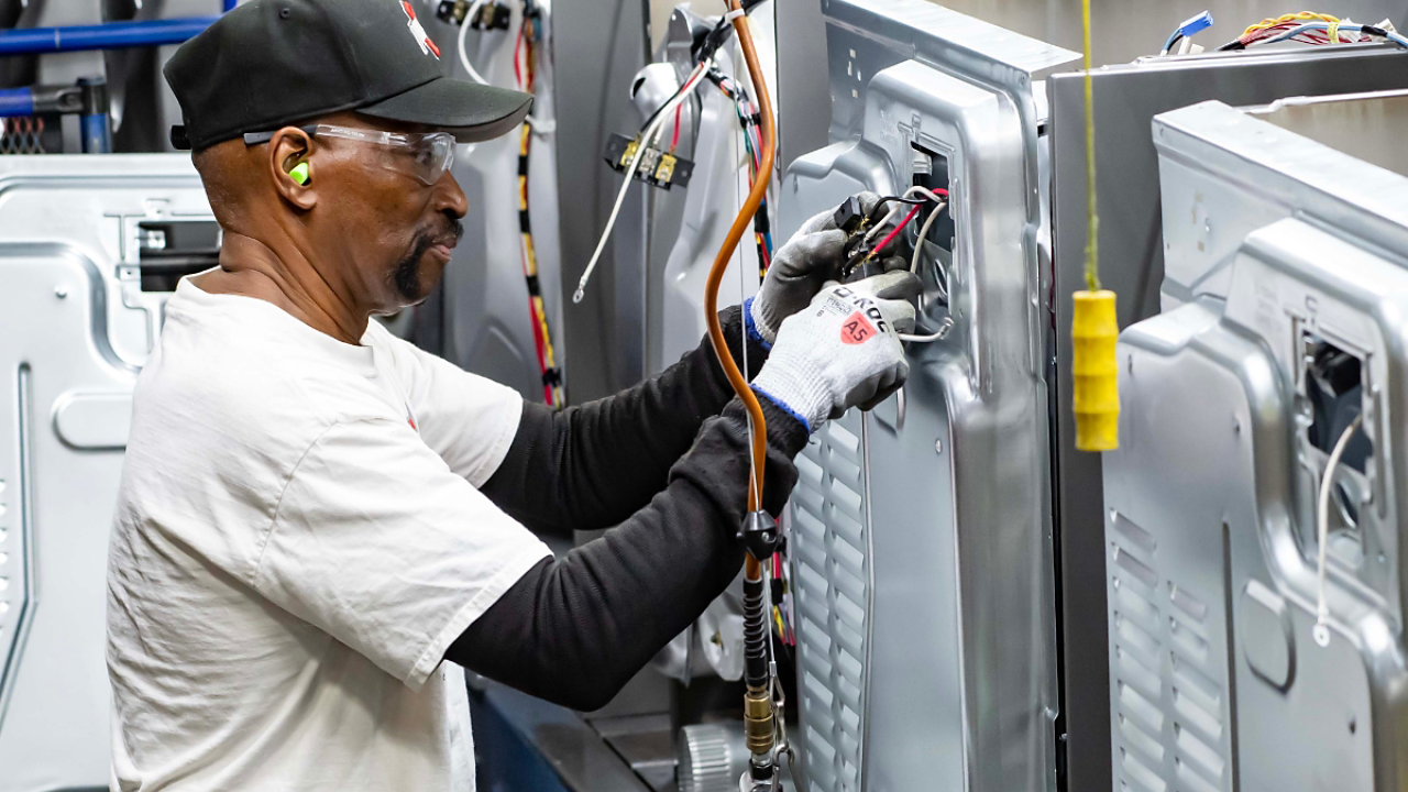 Worker assembling washing machine