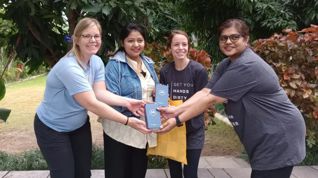 Four people smiling and holding Moto G boxes