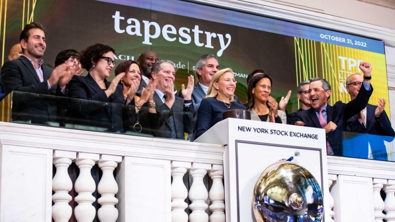 Joanne Crevoiserat ringing the opening bell at the NYSE. A team of people behind her.