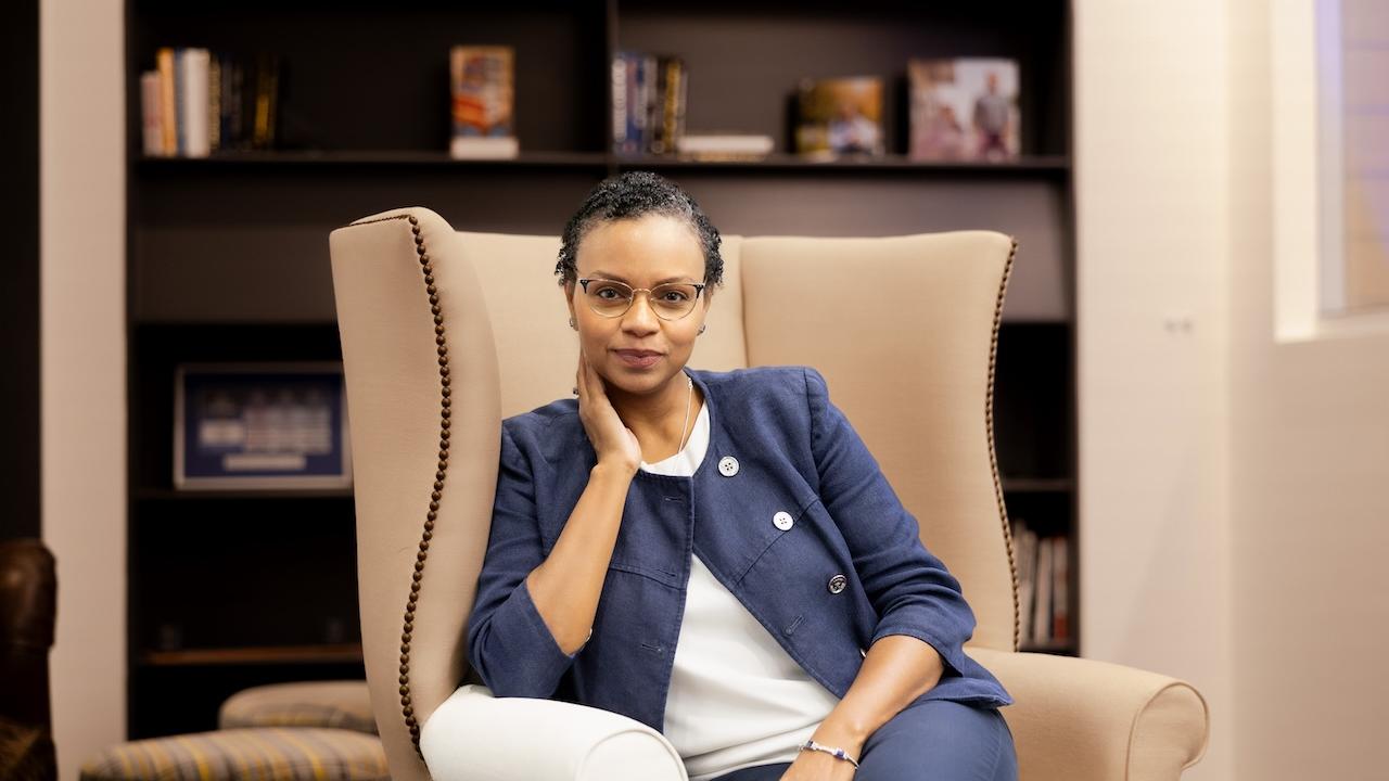 Natalie Lamarque sitting in a high back club chair at Principal headquarters with a soft smile. https://www.principal.com/about-us/purpose/natalie-lamarque-learning-harness-fear