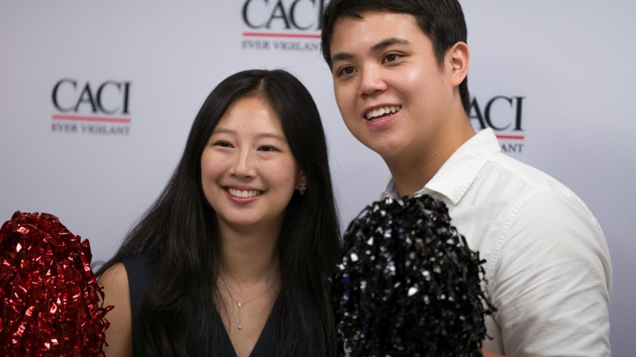 Two people at CACI's National Intern Day celebration