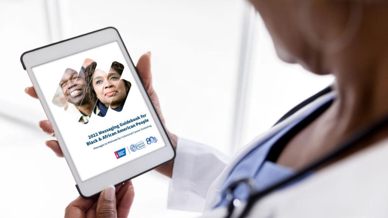 Doctor viewing the National Colorectal Cancer Roundtable's 2022 Messaging Guidebook on tablet