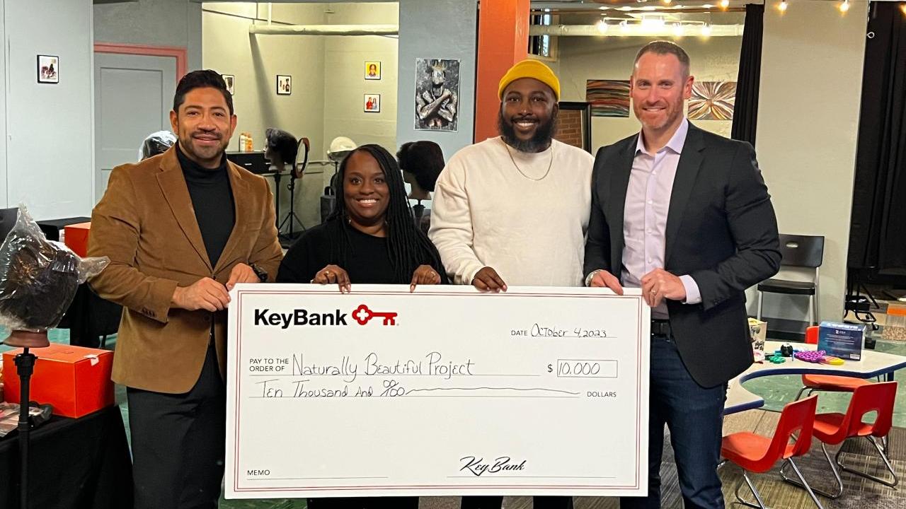 4 people holding a KeyBank Check
