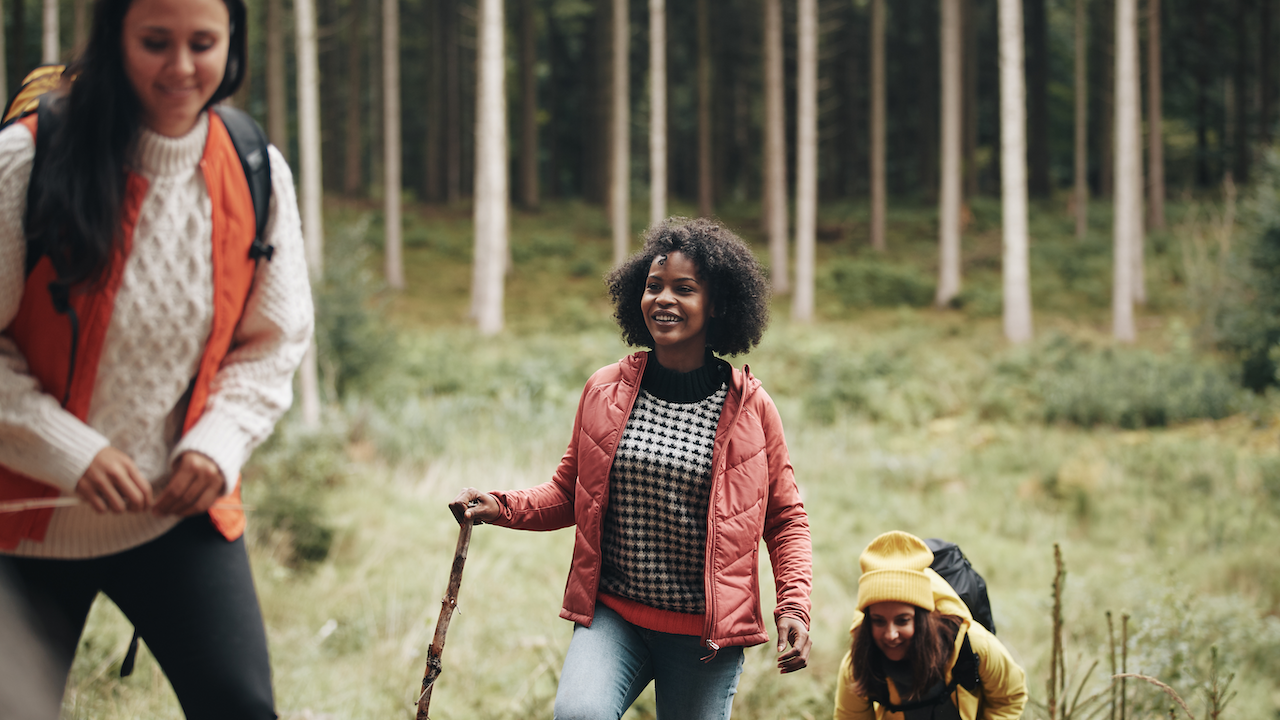 Woman and girls walking through forest