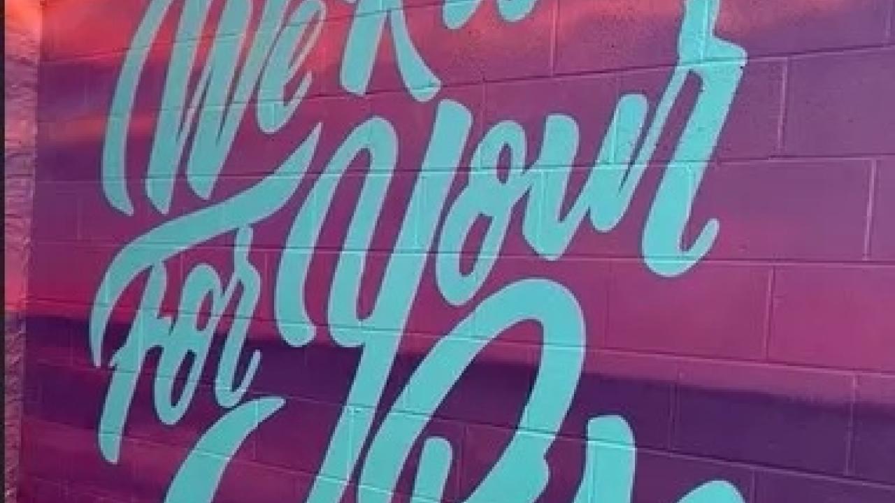 sign reading, "We Rise For Your Rise"