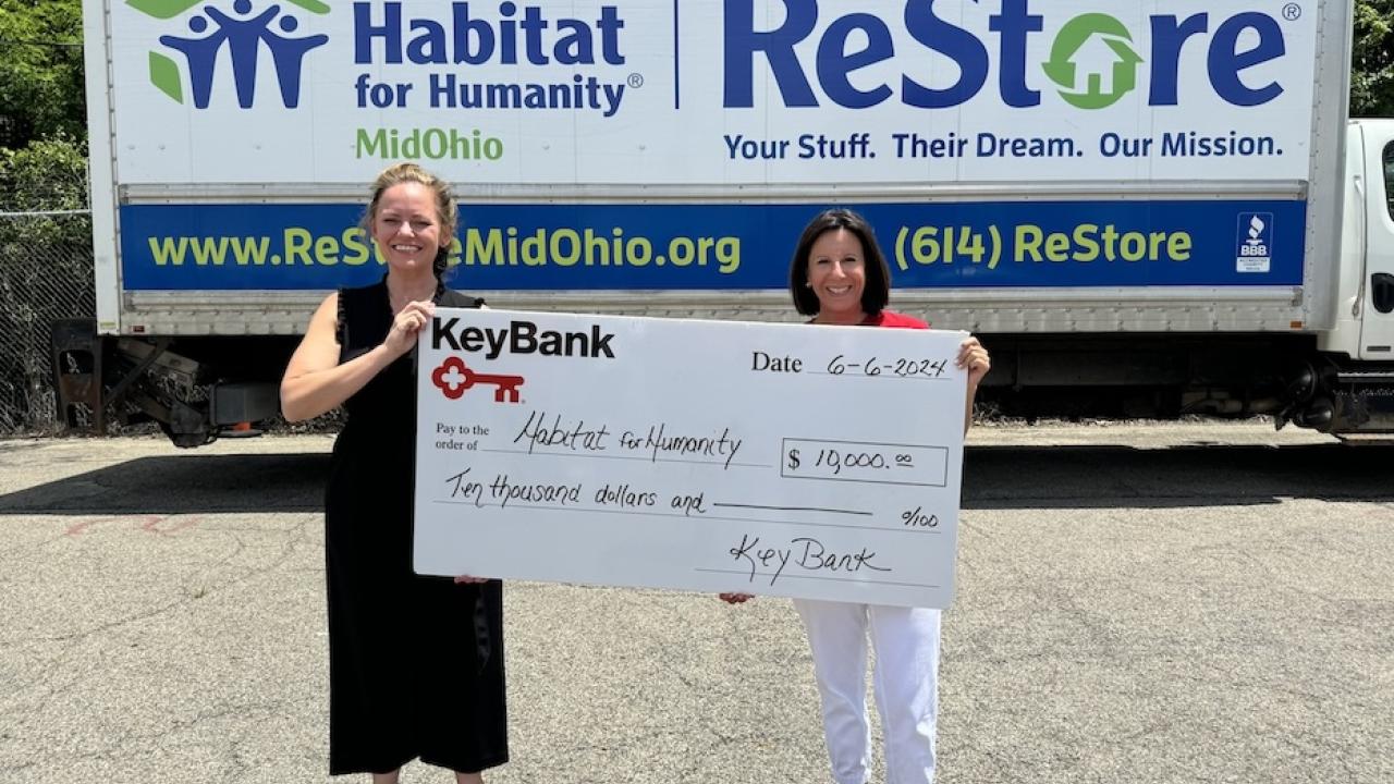 KeyBank volunteer shown with Habitat for Humanity volunteer with a $20,000 grant check.