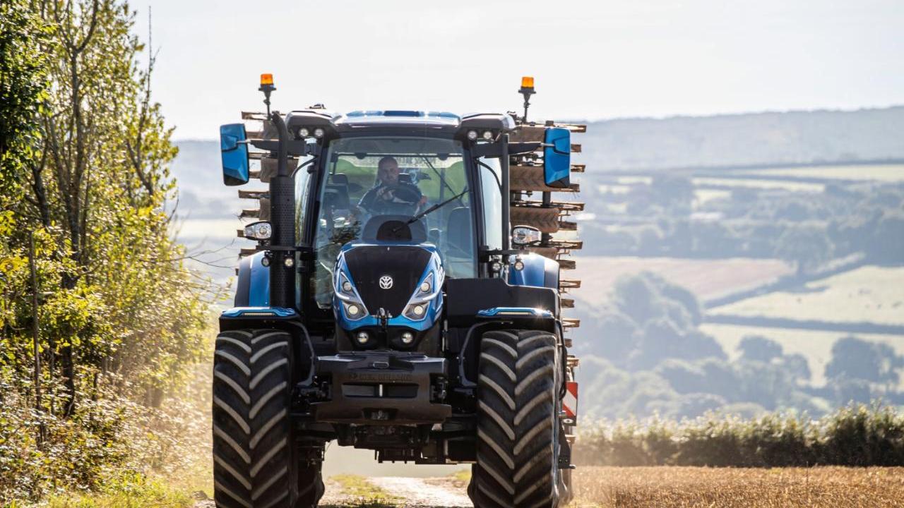 A tractor driving on a path next to a field.