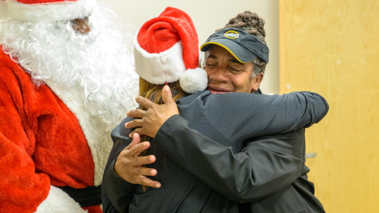 Cusomter hugging Entergy official wearing Santa