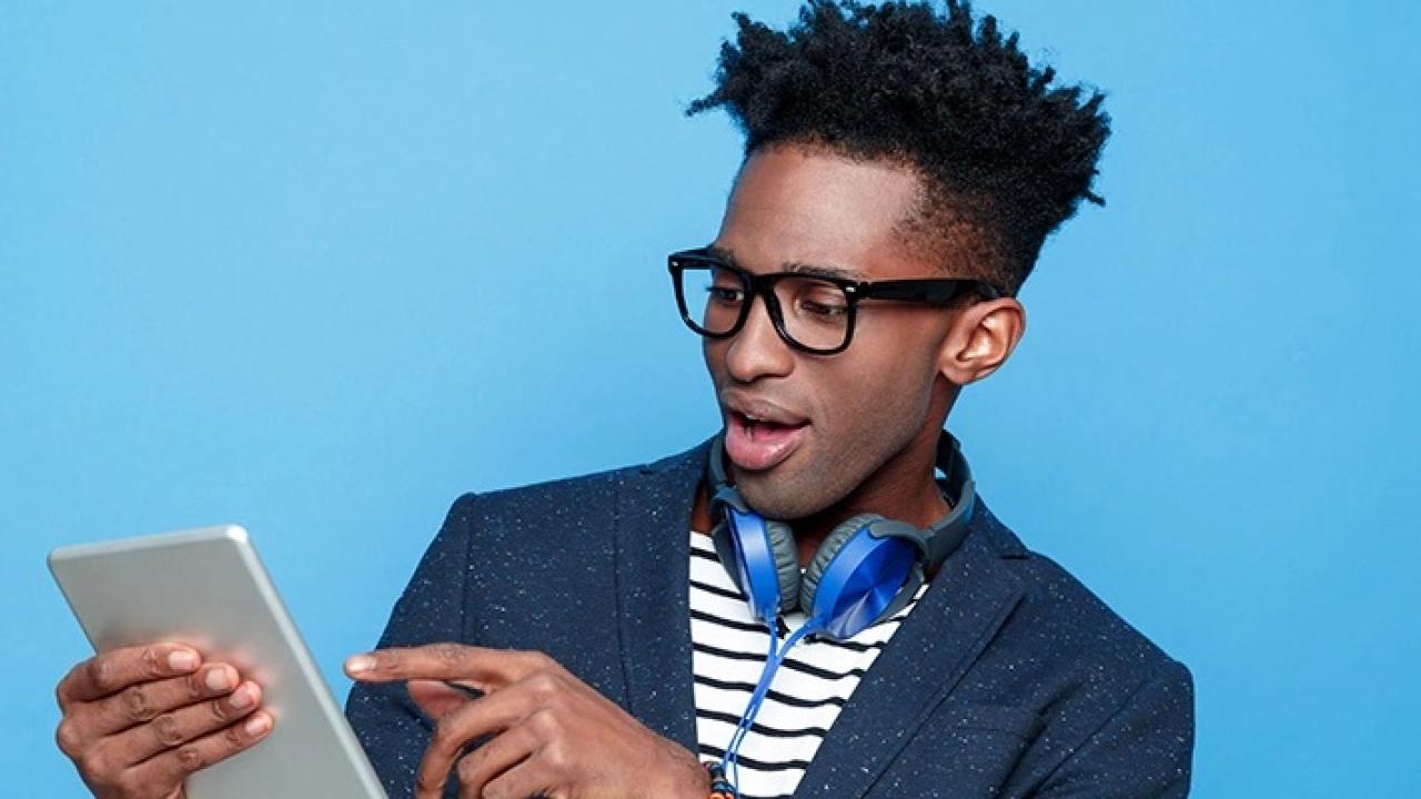 Young black make holding a tablet.
