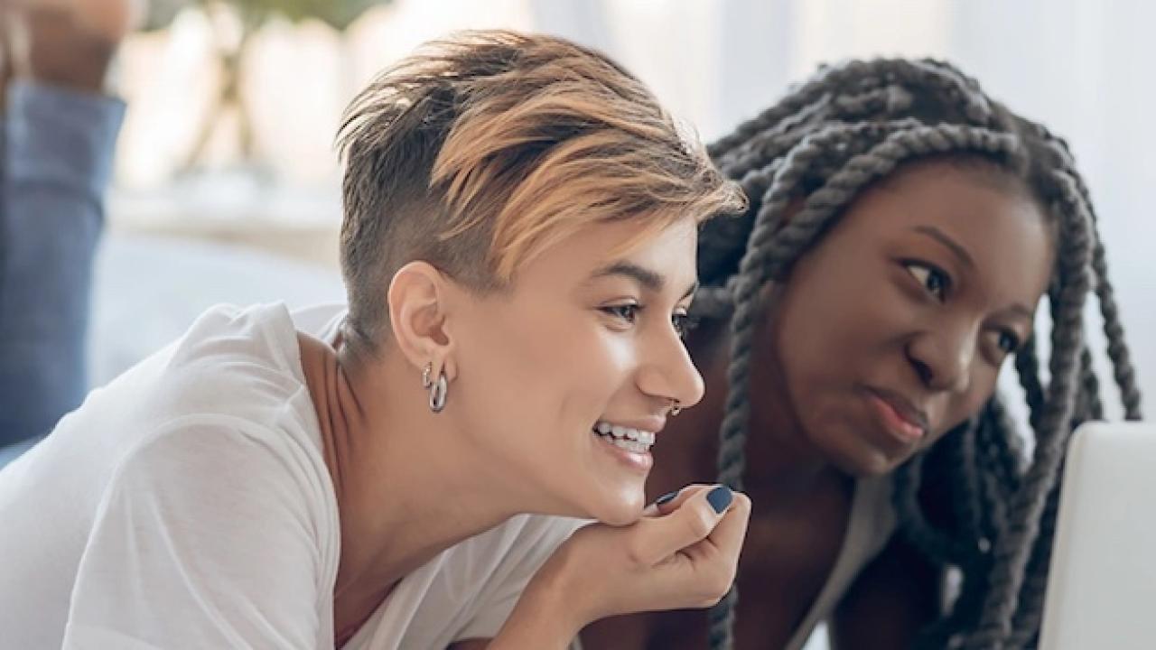 Two women viewing a laptop.