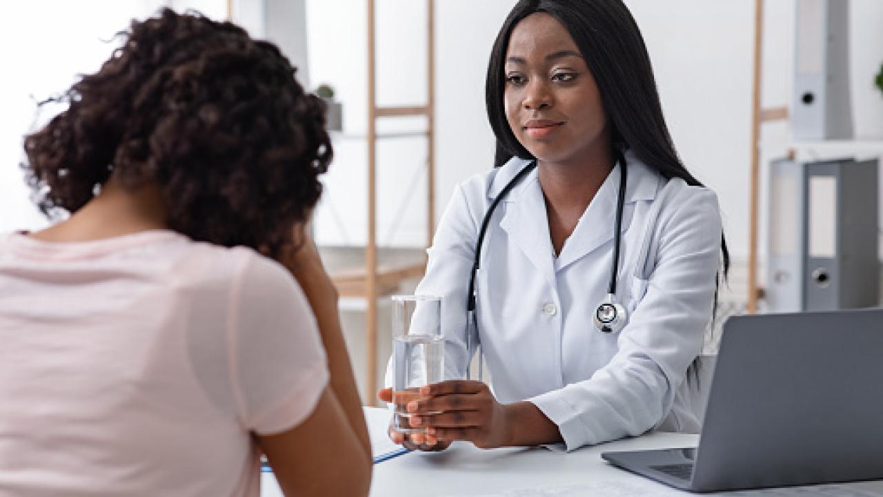 Black Female Doctor consulting with a patient.