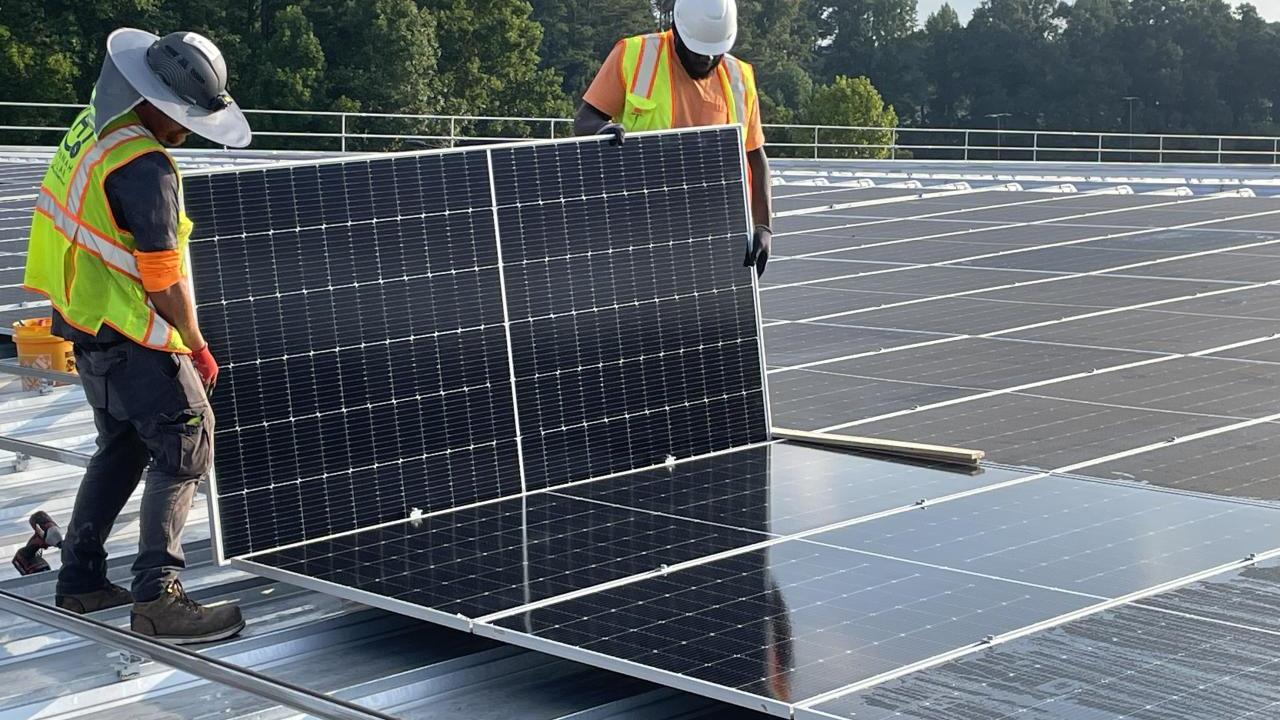Workers installing solar panels on roof of Southwire's North Campus plant