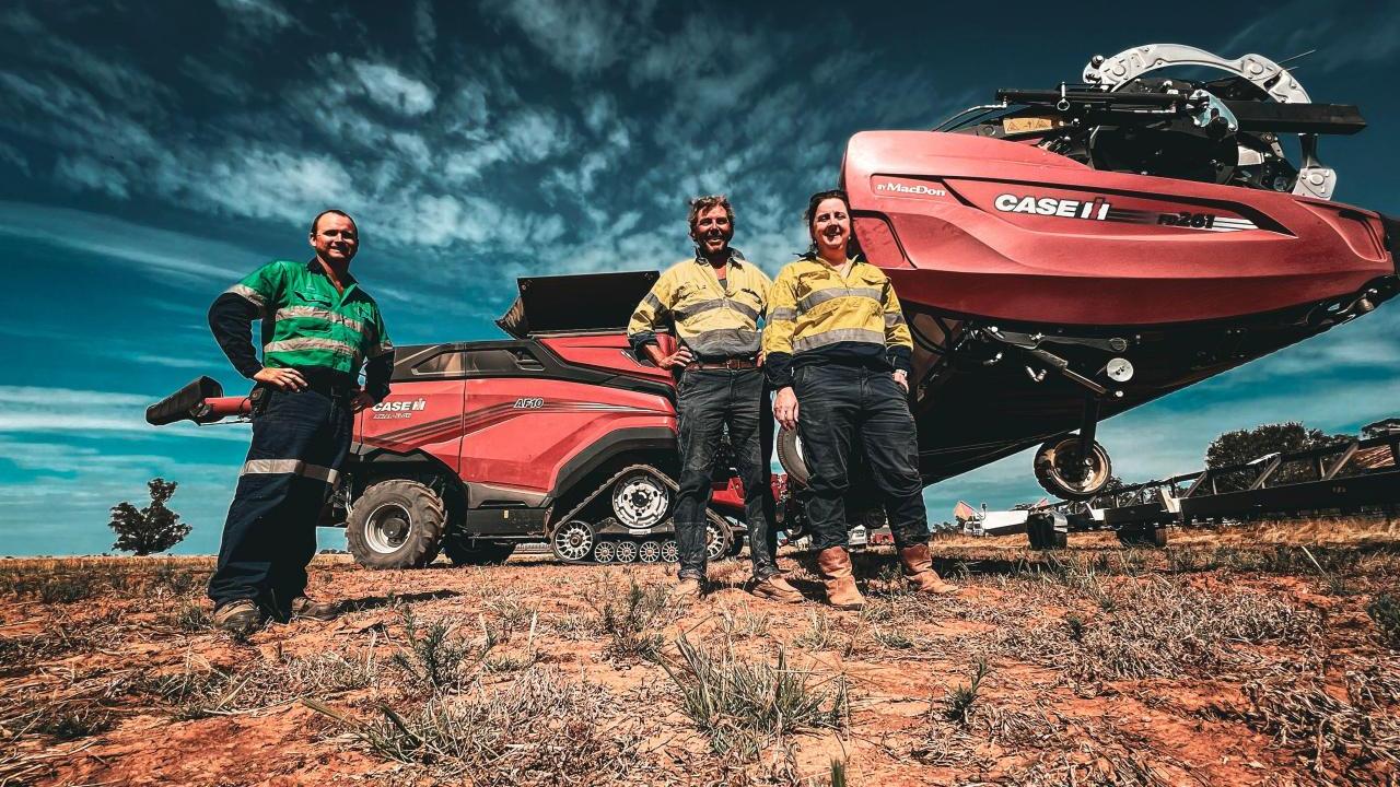 Three people standing outside near CASE IH equipment