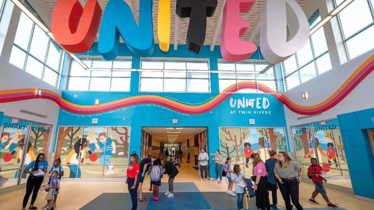 Banner of United at Twin Rivers elementary school. Students shown in the foreground.