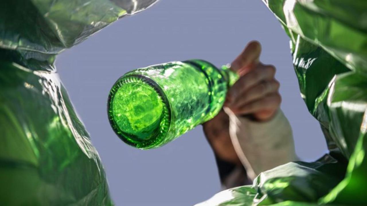 view of glass bottle being thrown in bag 