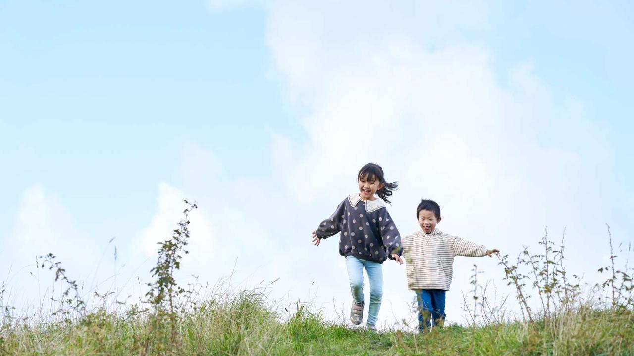Two children running on grass