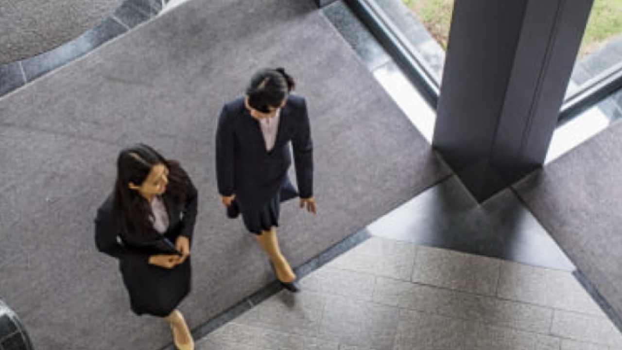 Two people walking through an office