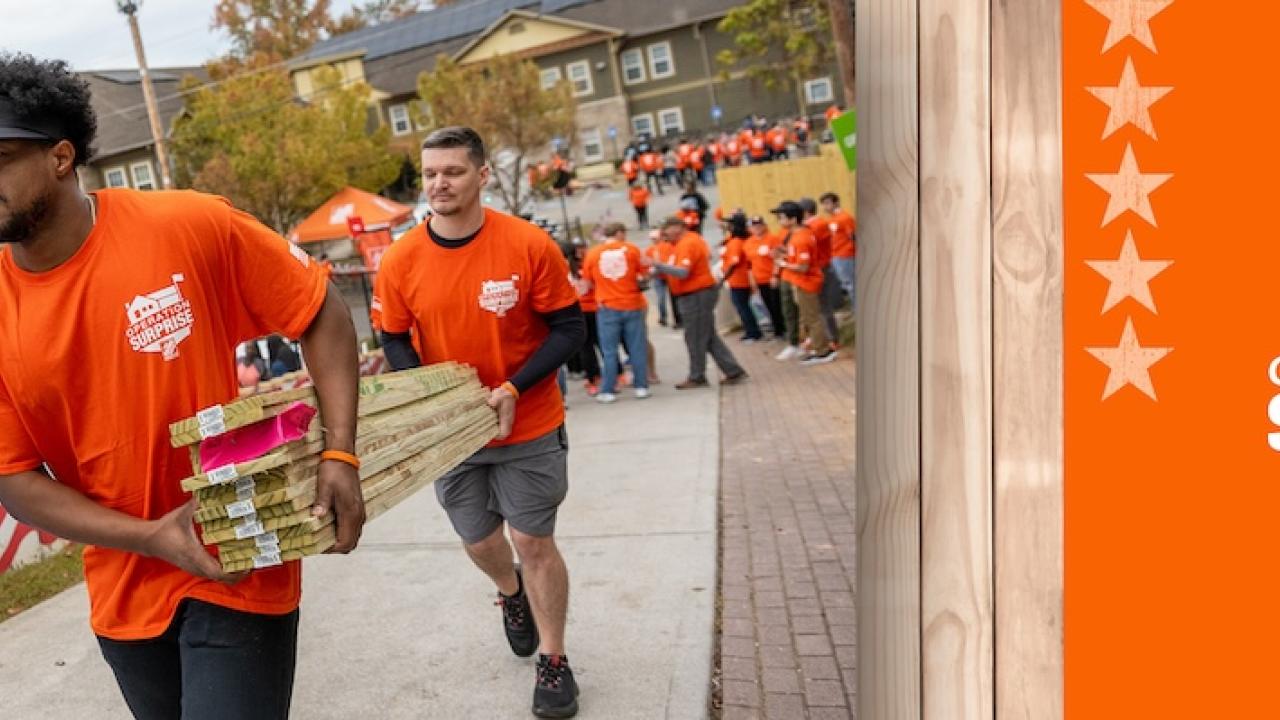 Operation Surprise! The Home Depot volunteers shown carrying lumber.