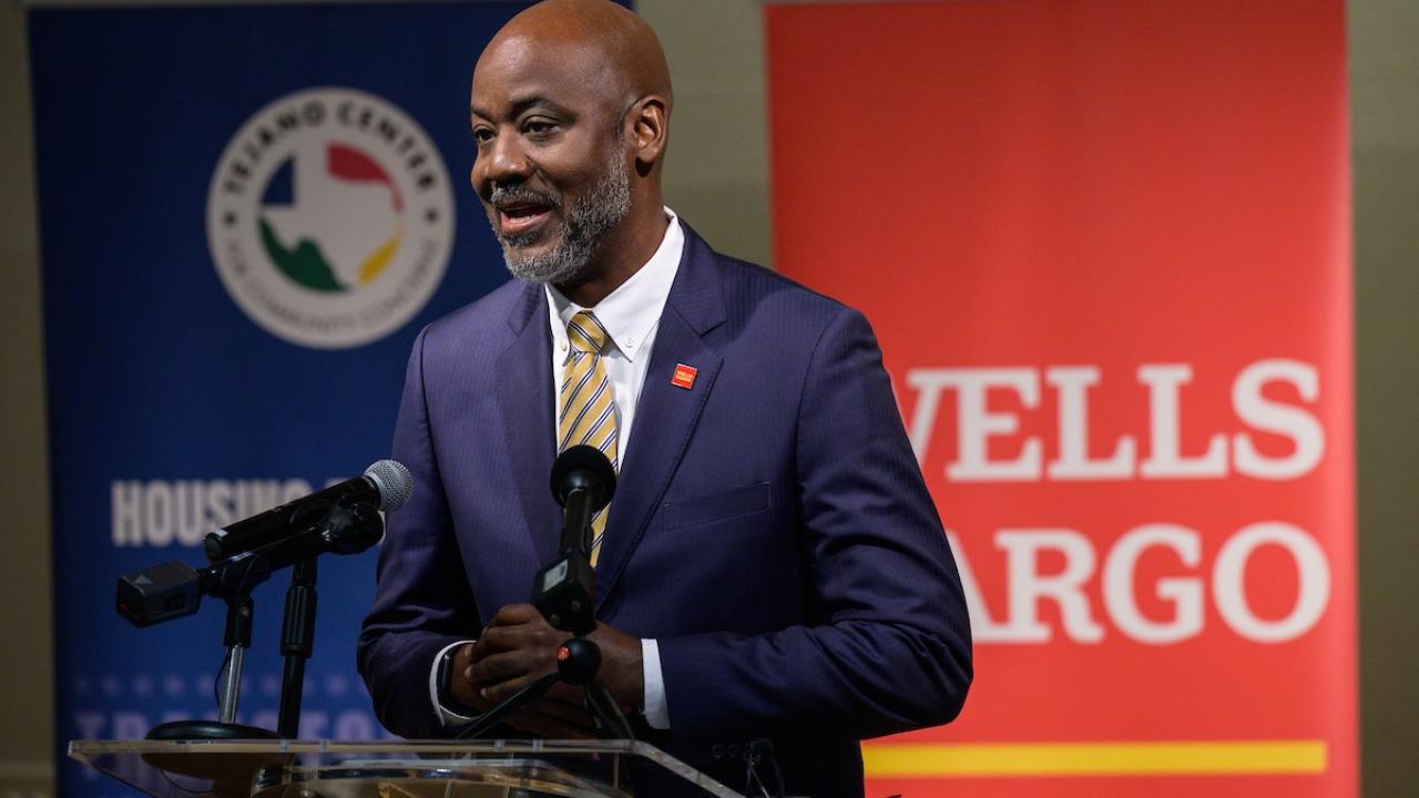 Man stands at podium with Wells Fargo sign behind him