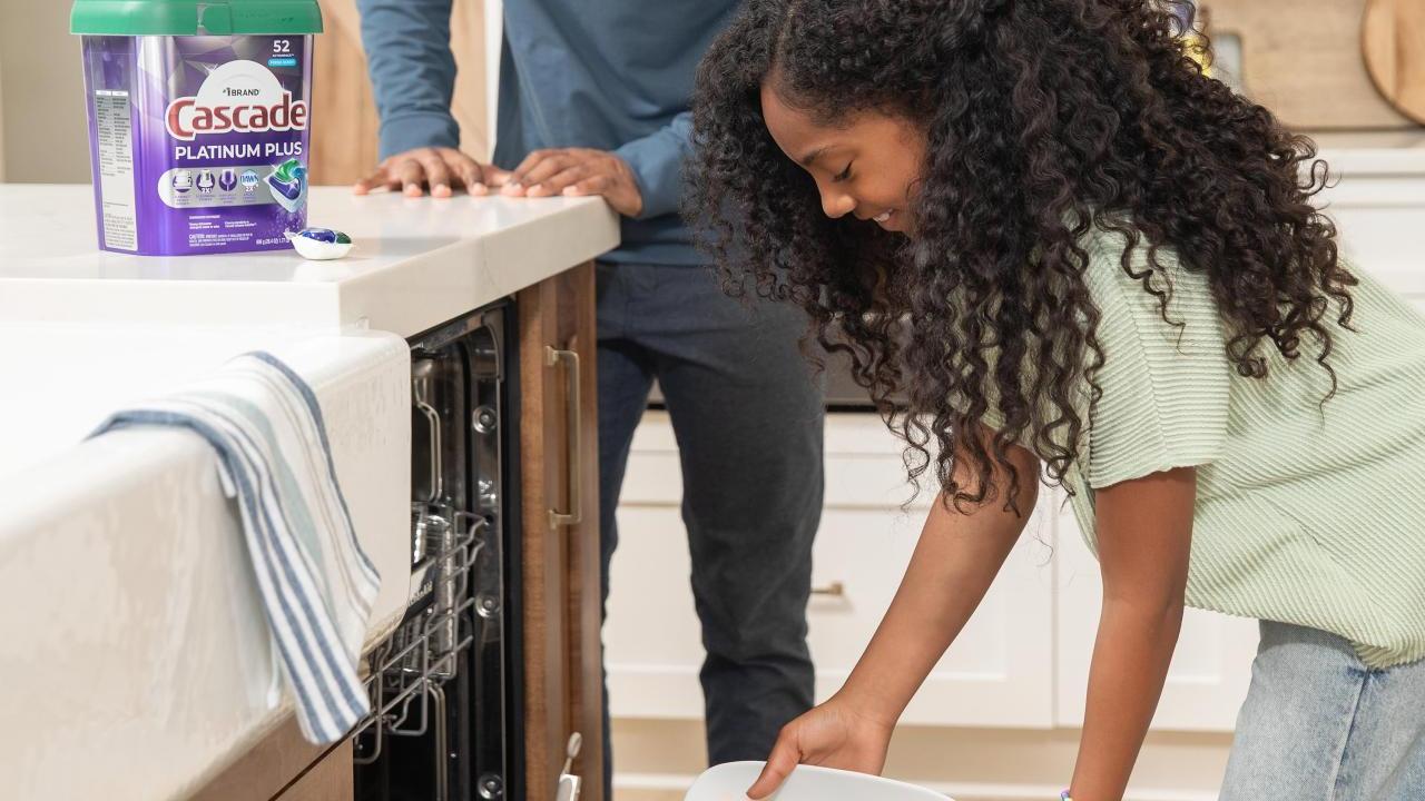 two people loading a dishwaser
