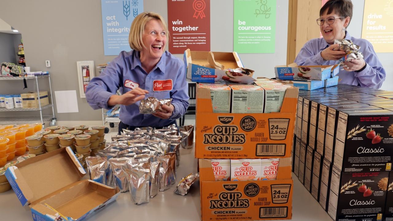 Employees of Post Consumer Brands pack bags of food