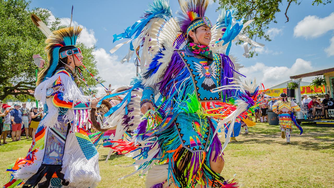 Native Americans wearing traditional dress 
