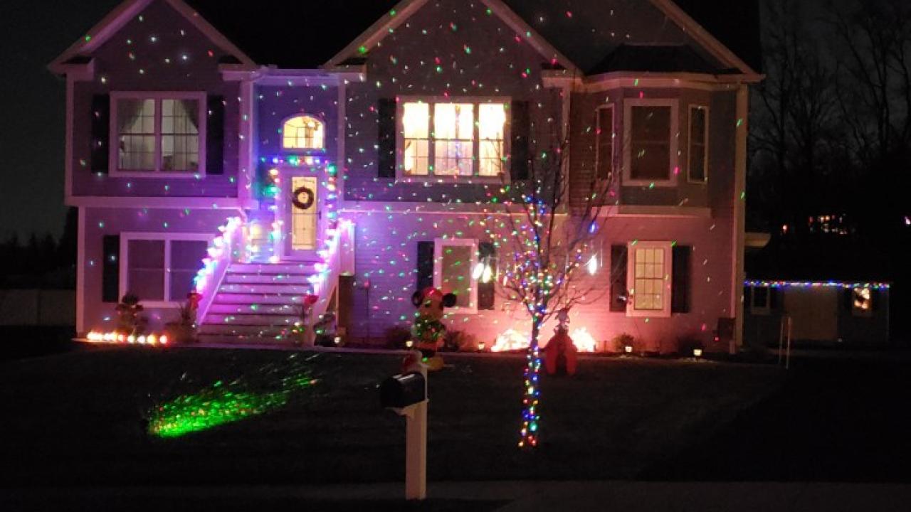 Home at night shown lit up with holiday lighting.