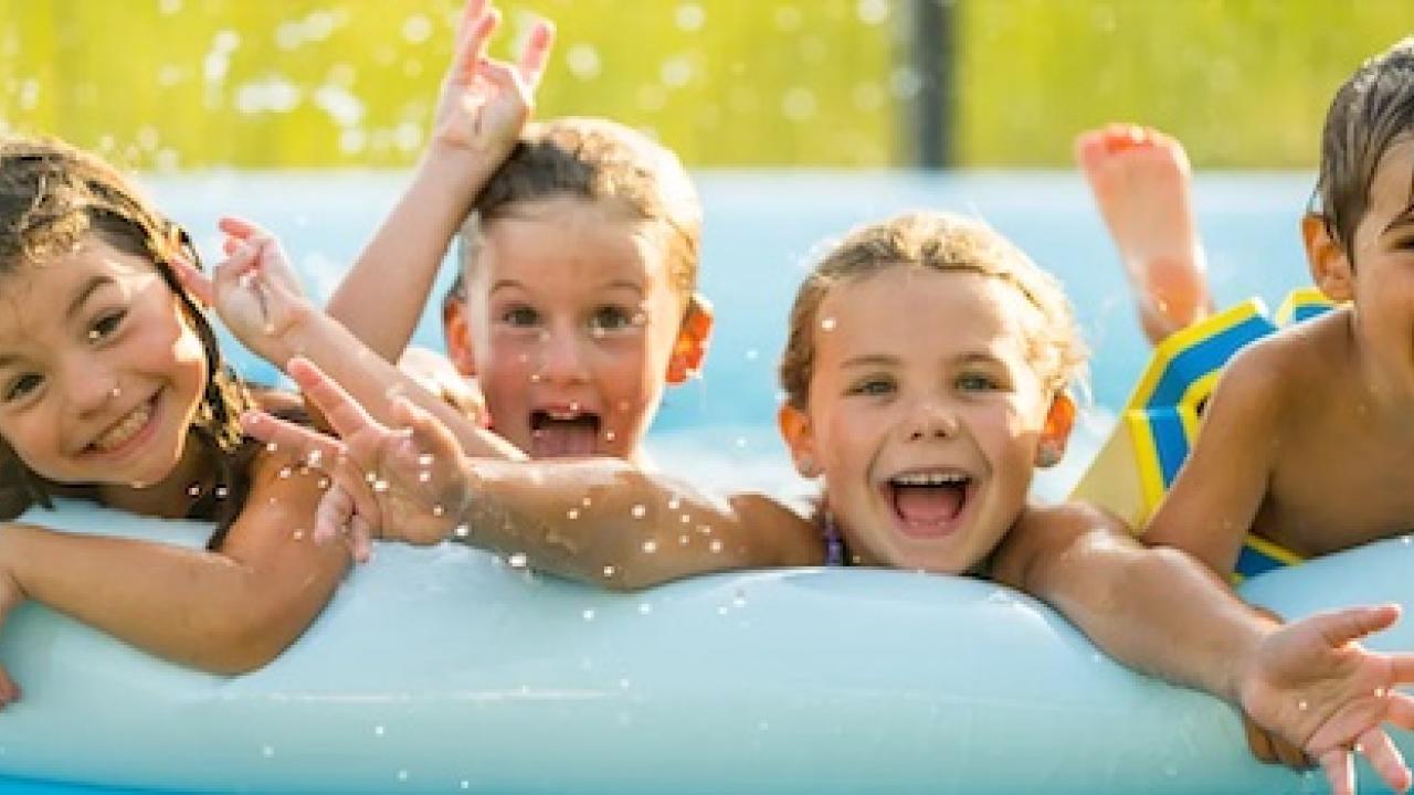 Four children in a kiddie pool.