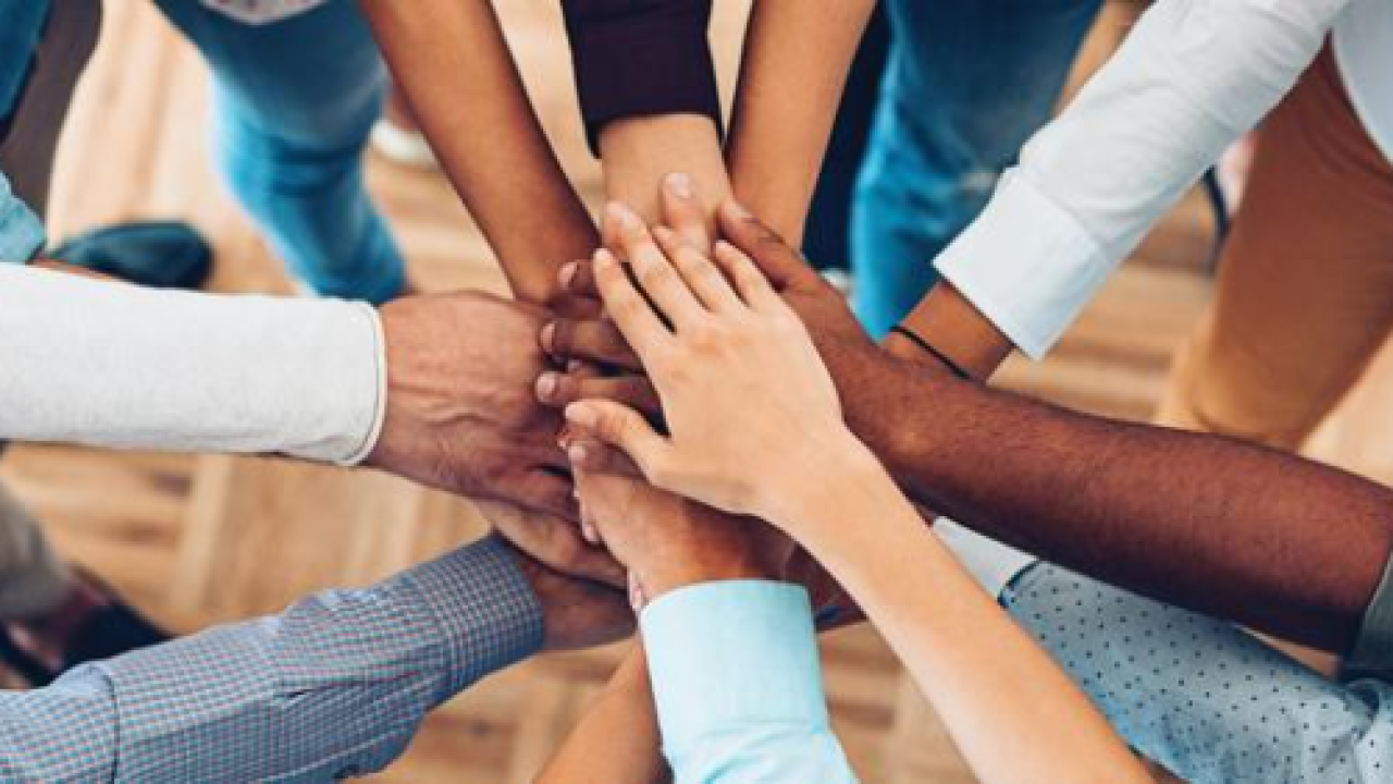 Hands in a circle on top of each other; as in partnership or an oath.