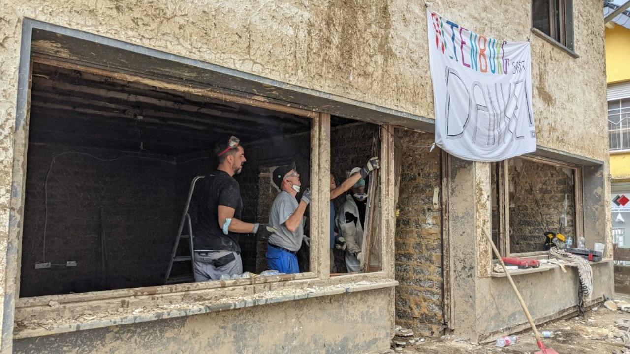 employees rebuilding home destroyed by flooding