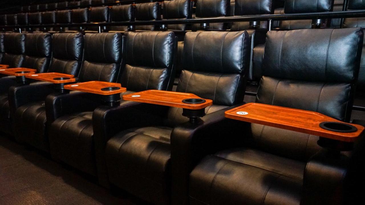 empty rows of leather seats in an auditorium 