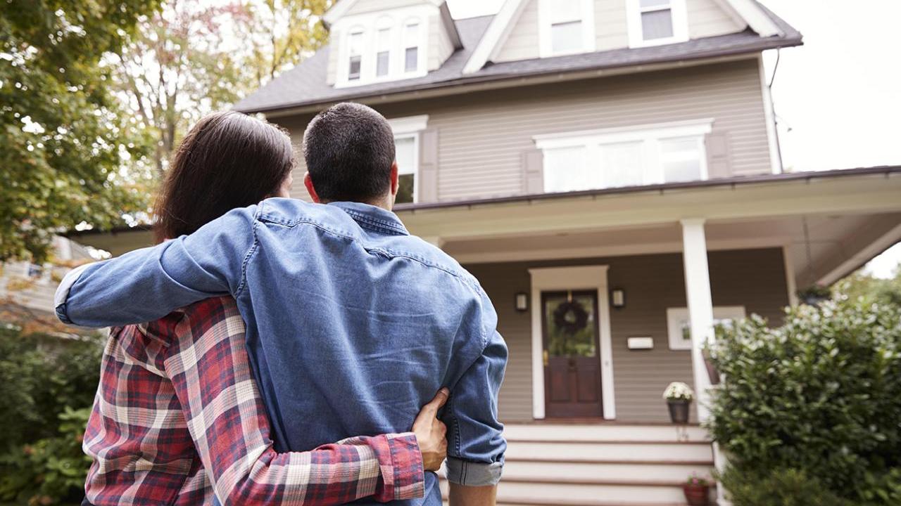 A couple embracing as they look at their new home.
