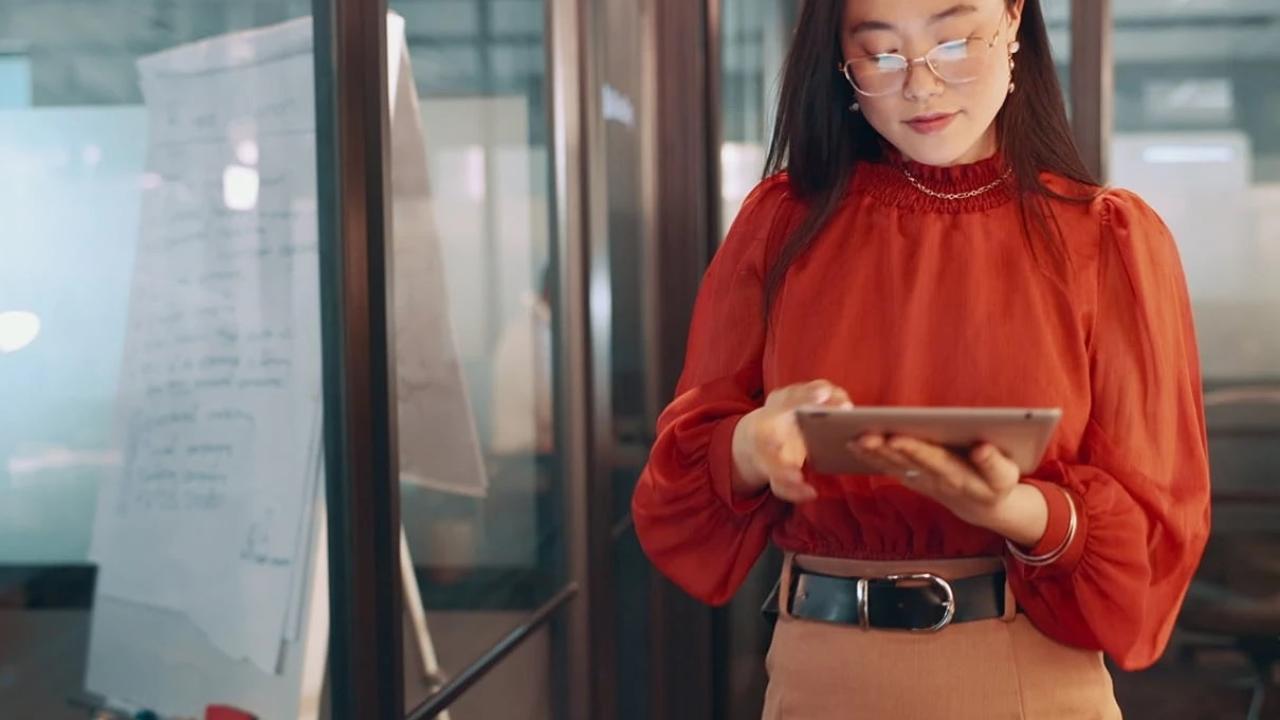 A person wearing a bright colour blouse, using a tablet PC