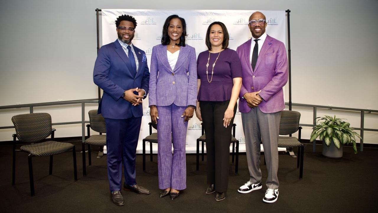 Four people standing in a conference room
