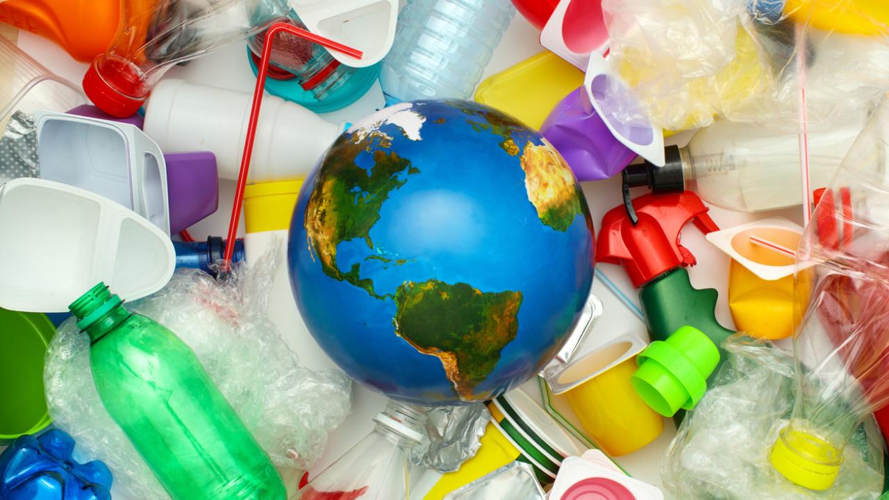 toy earth with a pile of plastics around it