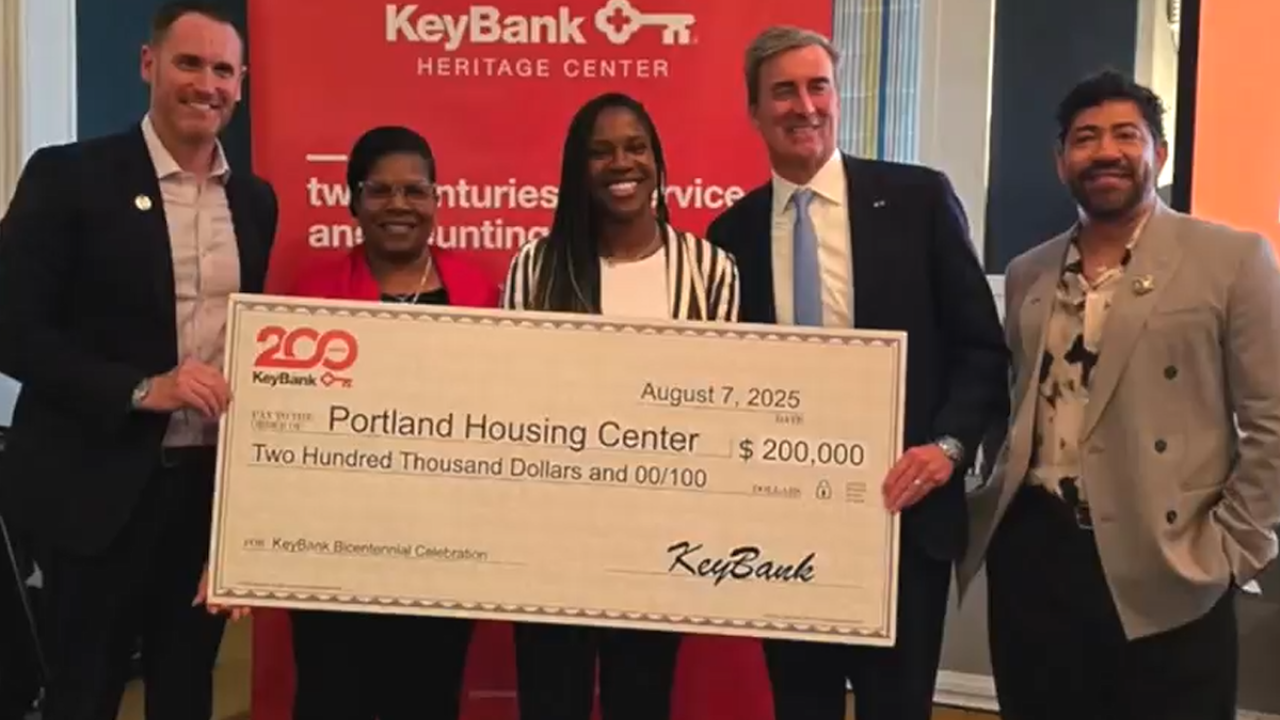 KeyBank team with the Arrive team with a $200,000 grant check.