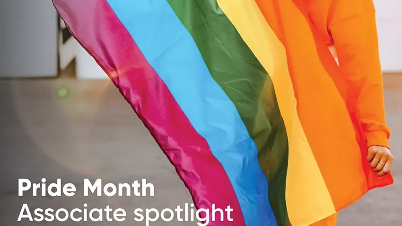 A person holding a rainbow flag. "Pride Month Associate spotlight"