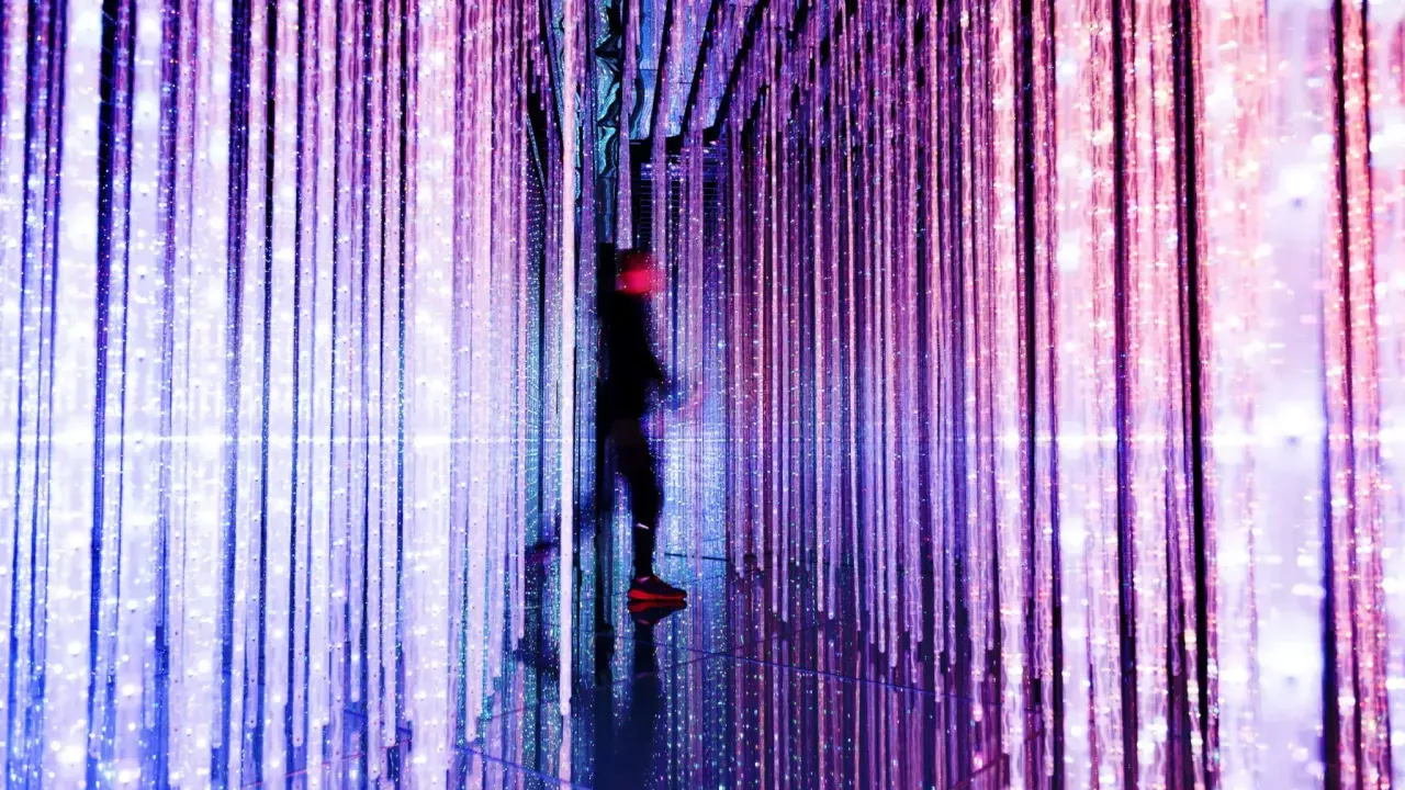 Figure walking through room with vertical purple lights