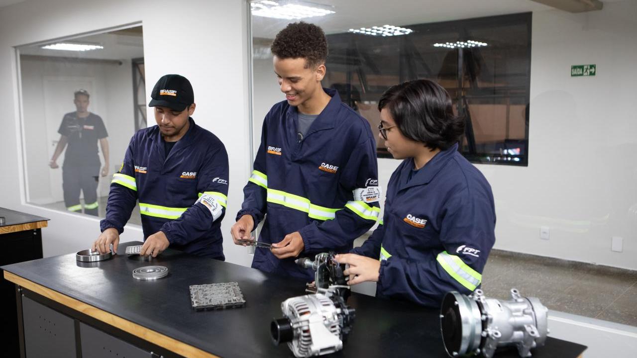 Three people stood at a table looking at mechanical components